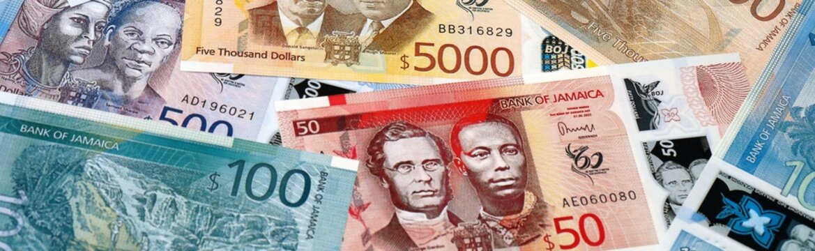 Jamaican dollar money bills in pile on table. Jamaica JMD currency cash close up