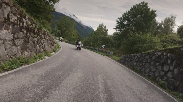 A tracking shot of motorcyclists riding on a narrow road near Vinica, Slovenia