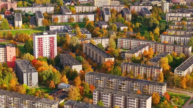 Autumn trees frame apartment blocks and roads across Mazeikiai Lithuania