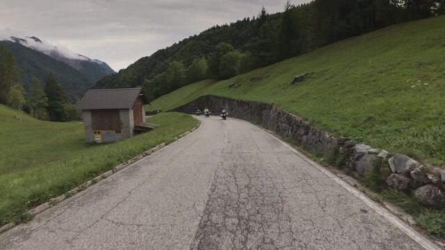 A tracking shot of motorcyclists riding on a narrow road near Vinica, Slovenia