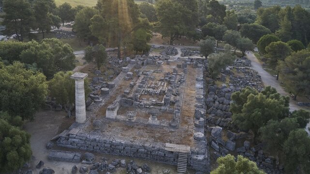 Temple of Zeus in backlight, architectural remains in a forest landscape with a visible stone column, drone shot, archaeological site, Ancient Olympia, Olympia, Peloponnese, Greece