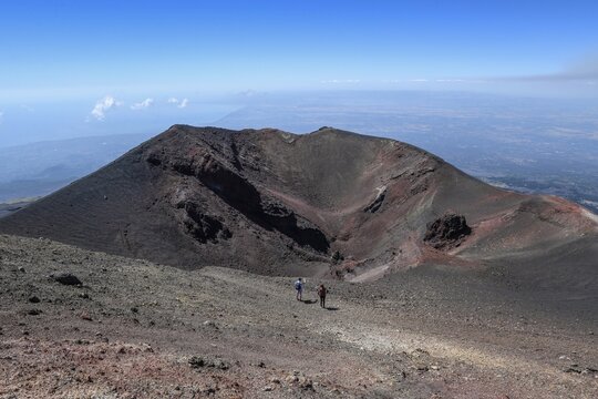 Hikers in the crater landscape of the volcano Etna, summit region, province of Catania, Sicily, Italy