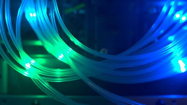 60 FPS Close up of fiber optic patch cables with blue to green LED data pulses in server rack