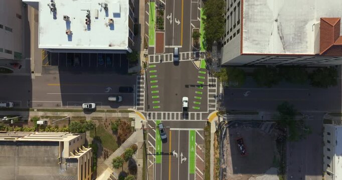 People walking briskly across urban crossroad in Sarasota, Florida, during peak hours, illustrating movement, speed, and the daily flow of city transportation.