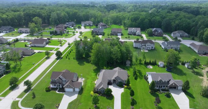 Private residential houses in rural suburban sprawl area in Cleveland, Ohio. Upscale suburban homes with large backyards and green grassy lawns in summer season.