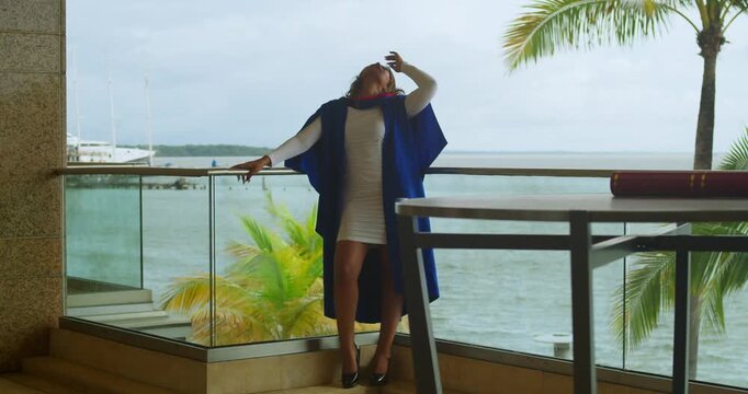Portrait of a young graduate celebrating her degree completion near an industrial harbor.