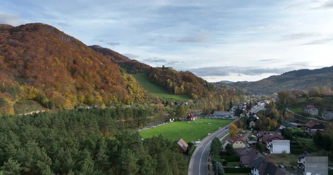 Aerial flight over Rytro village and river valley in autumn
