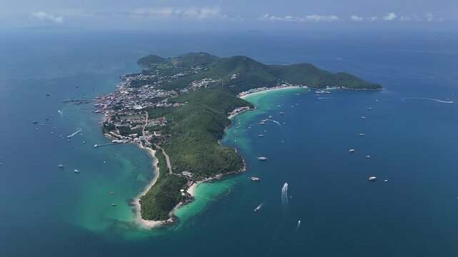 Wide panoramic aerial view of Koh Larn island in Pattaya Thailand showing the green peninsula white sand beaches vibrant turquoise coral reefs and boats floating in the deep blue tropical ocean waters