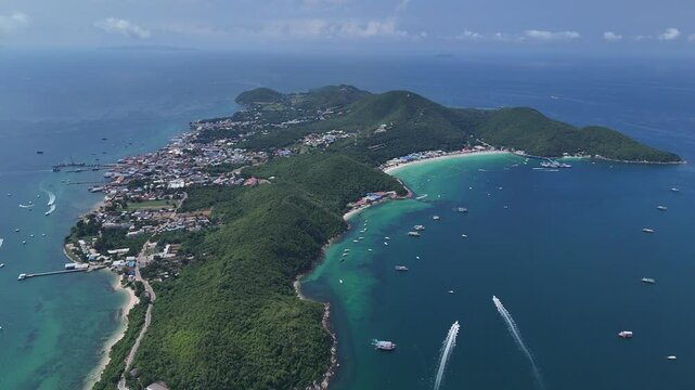 Stunning high altitude aerial view of Koh Larn island in Pattaya Thailand showing lush green mountains white sandy beaches clear turquoise sea waters and speedboats cruising across the calm blue ocean