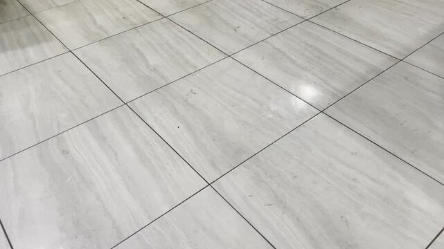 Diagonal marble tile floor texture with bright spot light reflection