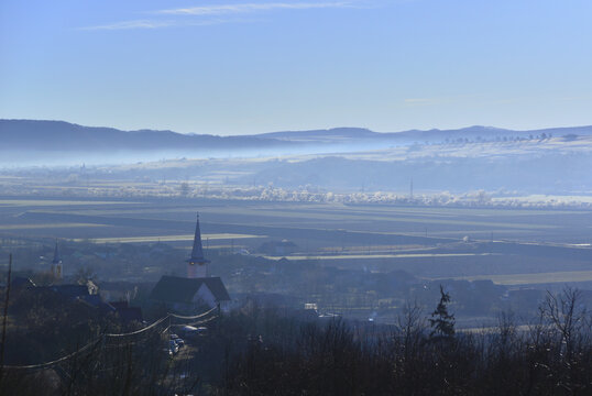 A late autumn morning in the Tarnava Mica river valley. Mist amongst the hills and frost-covered riverside vegetation.