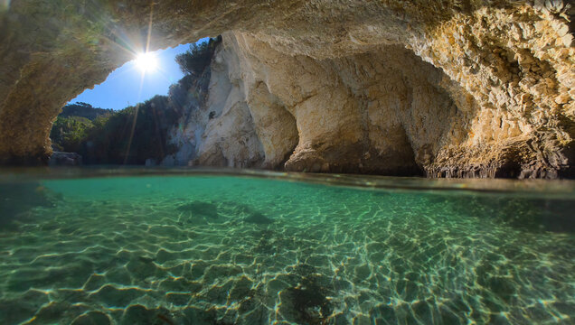 Underwater split photo of beautiful White Sea caves, rock formations and crystal clear emerald calm waters in small cove and beach of Kalami, Kefalonia island, Ioanian, Greece