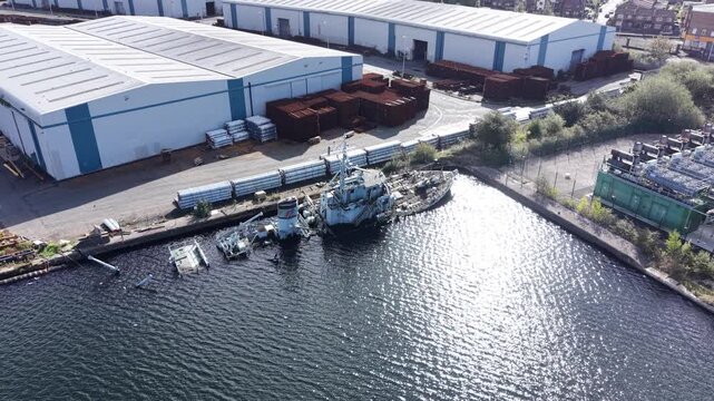 Aerial drone 4K footage showing the sinking hull of HMS Bronington with exposed framework illuminated by warm natural sunlight UK