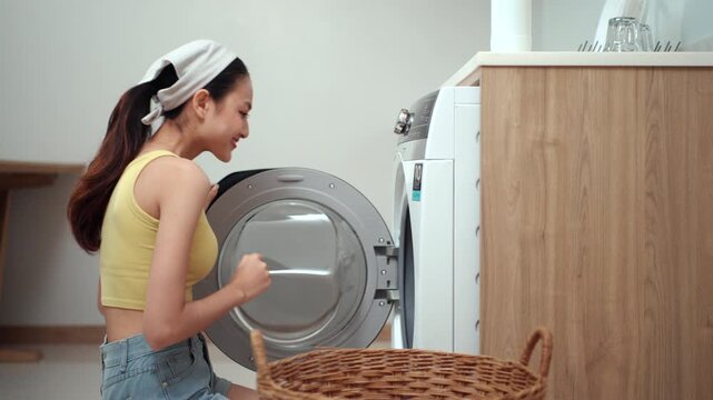 Housewife taking freshly washed clothes from a washing machine and enjoying their clean, fresh scent, highlighting laundry care, detergent, fabric softener. Household chores concept.
