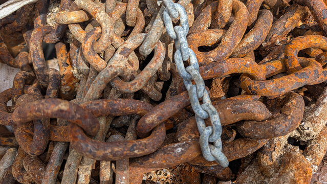 Close-up of heavily rusted metal chains with corrosion. 
