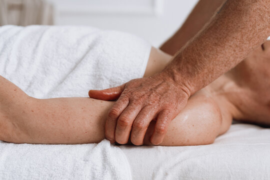 Man performing shoulder massage on woman in spa clinic