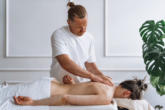 Man giving woman a back massage in a wellness salon