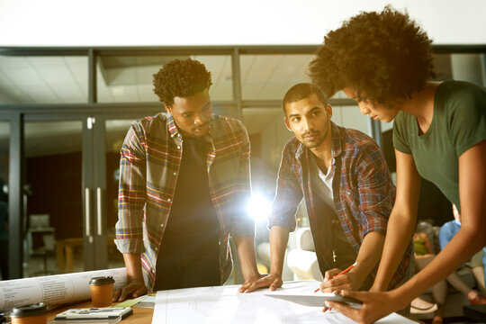 Architecture, night and people with blueprint in office for design, floorplan and building project. Creative team, engineering and workers with paperwork for planning, layout and renovation meeting