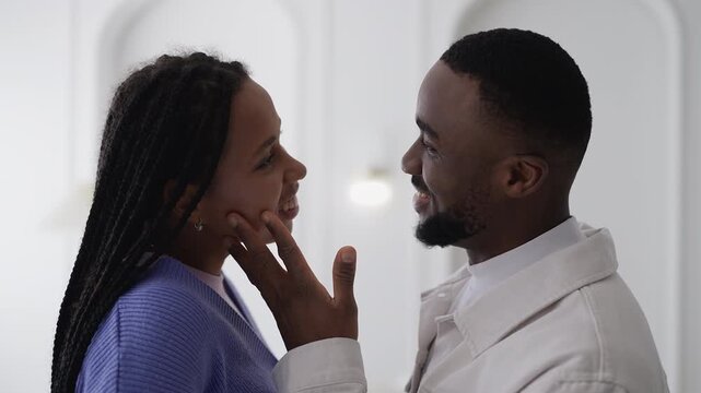 Young African American couple kissing and hugging tenderly, loving relationship