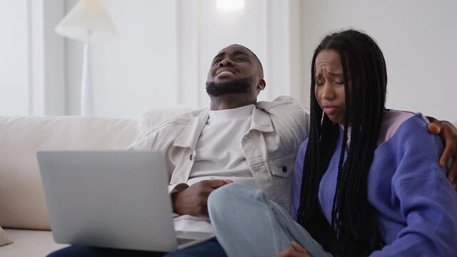 Young Black couple read bad news email and close laptop, worried about debts
