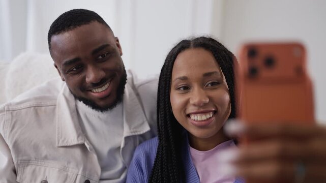African American couple make online video call to friends using cellphone
