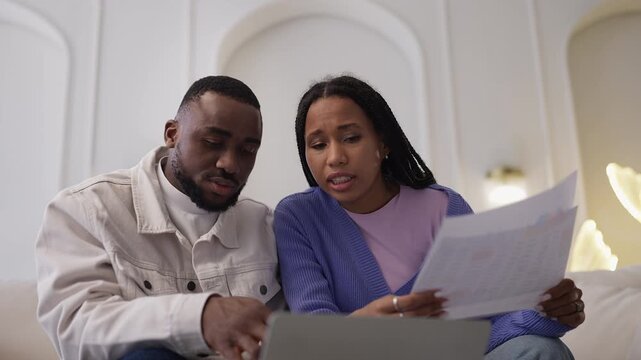 Black couple business owners discuss expenses and financial strategy at home