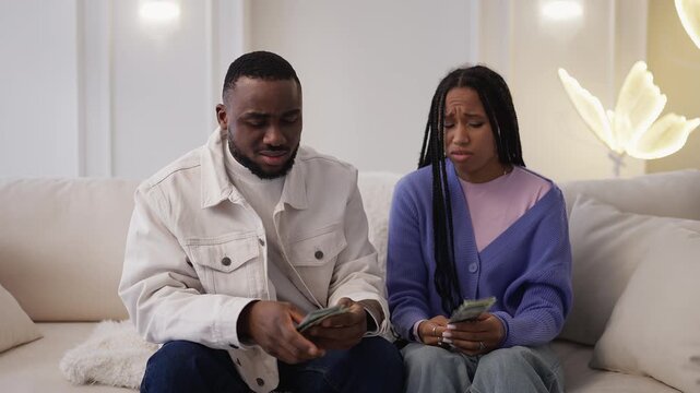 Young African American couple calculate family budget, worried about debts