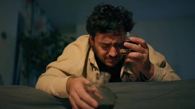 Blackout from alcohol abuse as adult male lies motionless on mattress. Deep psychological sorrow