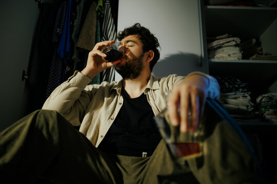 Exhausted man swallows strong alcohol trying to forget unpaid debt notices and career failure
