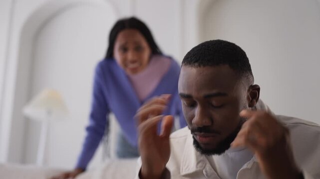 Black man feels stressed during fight with girlfriend at home, closes his ears