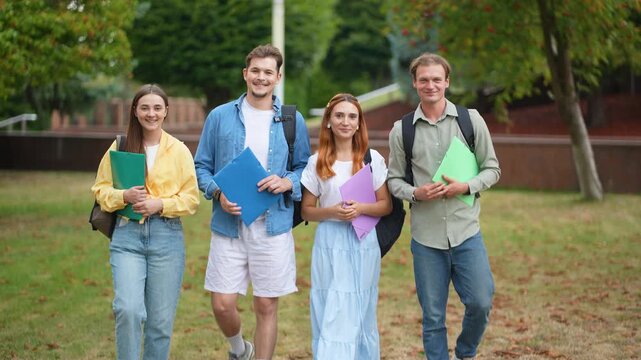 Group of university students walking in the campus park