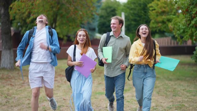 Happy university students running together after exams