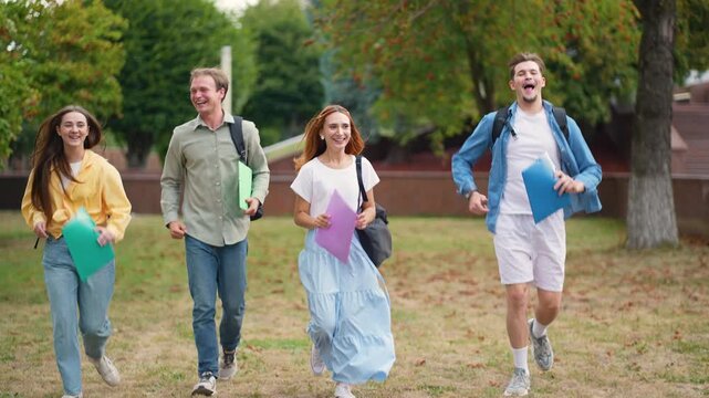 Group of happy students running together in university campus park