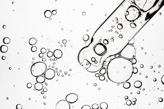 Clear liquid with oil bubbles and pipette applicator representing skincare science
