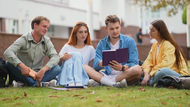 Group of college students studying together on campus lawn