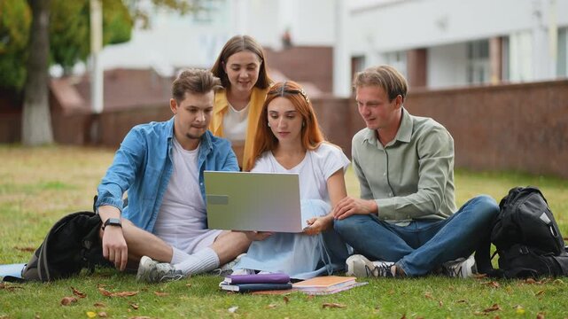 Group of college students studying together on campus lawn
