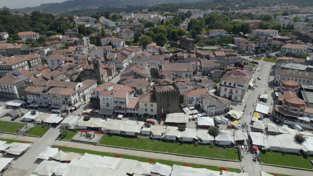 Aerial view of the historic town of Ponte de Lima with its medieval tower, traditional white buildings, and market stalls set up in the square in Ponte de Lima, Viana do Castelo Dist, Portugal.