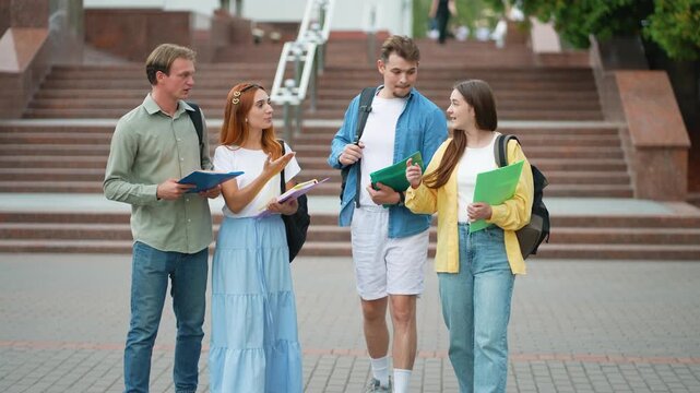 Group of university students walking and talking on campus