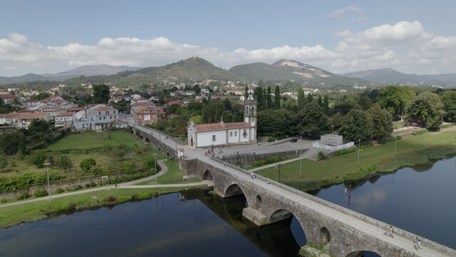 Aerial view of the historic Ponte de Lima bridge spanning the Lima River with the Igreja de Santo Antonio da Torre and surrounding town in Ponte de Lima, Viana do Castelo Dist, Portugal.