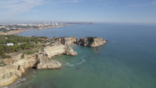 Aerial view of the rugged cliffs and turquoise waters at Ponta Joao de Arens in Alvor, Faro, Portugal.