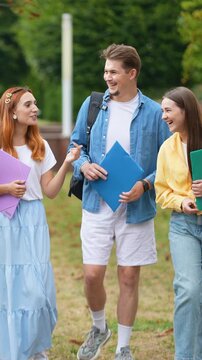 Group of university students walking and talking together on campus