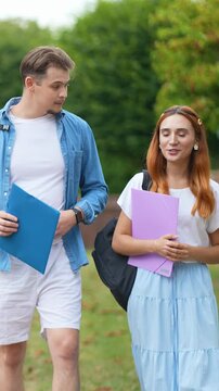 Two university students walking and talking together on campus