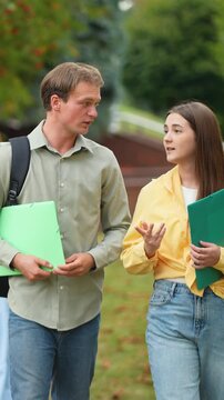 Young students enjoying conversation while walking through campus