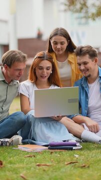 Group of college students studying together on campus lawn