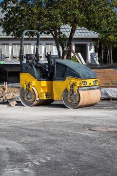 Road construction roller parked outdoors  in front residential building