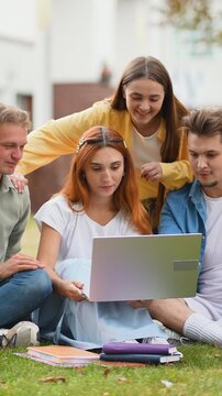 Group of college students working together on a laptop outdoors
