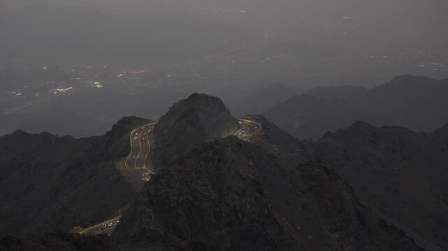 Taif, Saudi Arabia - Night illuminated winding mountain road in Al Hada, Taif with city lights and traffic, 4K footage video