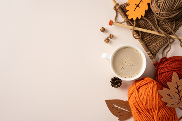 Fototapeta premium Cozy autumn knitting scene with yarn, needles and a warm cup of coffee on a neutral table with a lot of blank space
