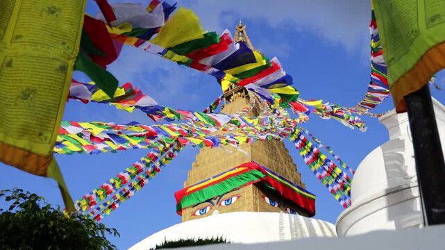 Sacred Buddhist stupa adorned with colorful prayer flags in Kathmandu, Nepal, surrounded by traditional religious architecture and a peaceful spiritual atmosphere