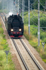 Historic TKt48 steam locomotive pulling a retro passenger train on the railway tracks near Chabowka, Poland © lumofoto